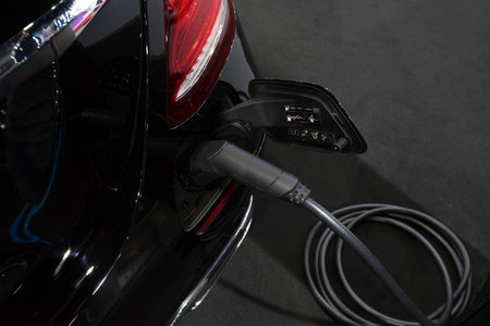Close up view of vehicle electric charging socket plug in to recharge in Bangkok, Thailand.