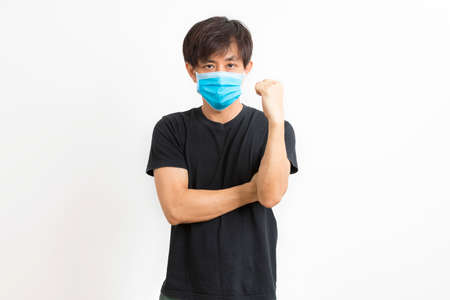 Asian man in t-shirt wear medical mask to protect COVID-19 isolated on white background. confidence gesture.の写真素材