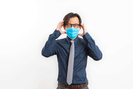 portrait of businessman wearing blue face mask suffer from covid-19 symptom isolated on white background.の写真素材