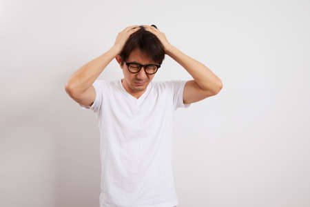 Asian middle-aged men having a headache stand on white background, health and elderly concept.の写真素材