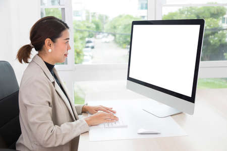 Beautiful Asian woman work from home, working on computer in living room at home. Social distancing lifestyle.の写真素材