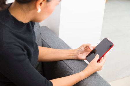 Close up of woman hand using smartphone, browsing internet, checking social media, sitting on the...
