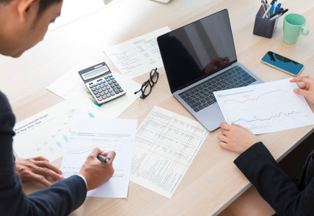 Consultation of Business man and business woman consider business plan in office with many document...