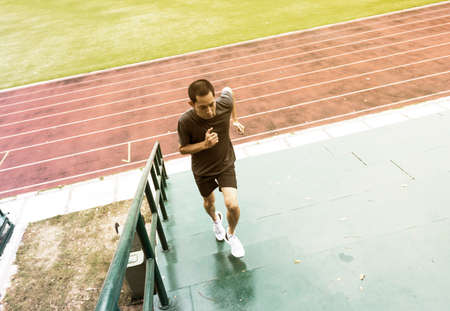 young man running upstairs at stadium background.の写真素材