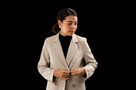 Asian businesswoman with brown suit standing with confidence on black background.の写真素材