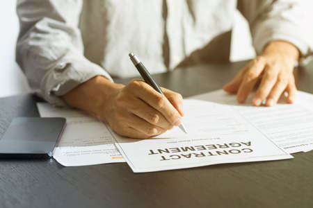 Business man signing document. Business man signing contract. Close up of business manager signing document on table.の写真素材