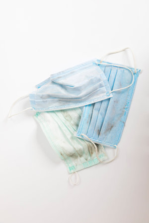 Used surgical face mask on white background.