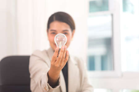 Asian businesswoman shows light bulb in modern office. creativity idea innovation inspiration in business concept.の写真素材