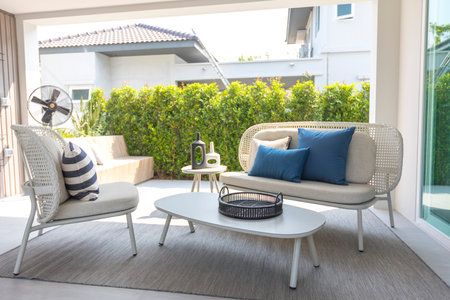 outdoor furniture rattan chairs, table and blue pillow by the home patio. Beautiful and cozy home...