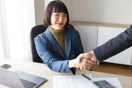 businesswoman and partners shake hands in the office.の写真素材