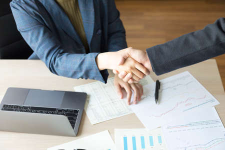 Two confidence businessman and businesswoman shaking hands close-up view of handsの写真素材
