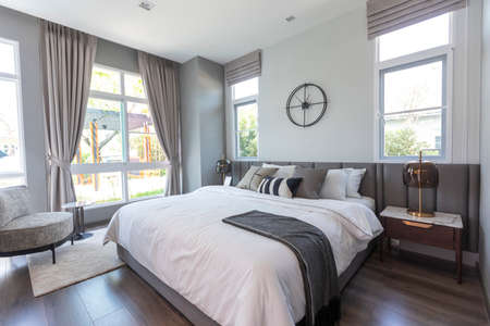 Stylish Bedroom and headboard with soft white and blue pillows setting,  cozy interior design.の写真素材