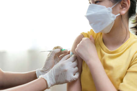 Close up of Young asian girl getting vaccinated or inoculation or virus Vaccine Injection.の写真素材