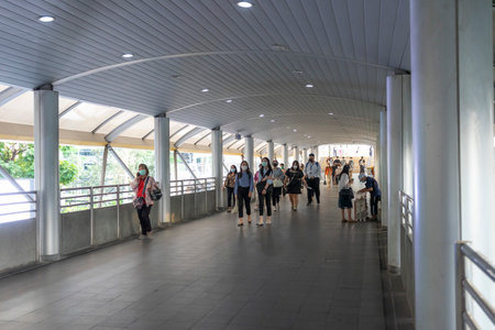 Bangkok, Thailand - Feb 19,2022 : Unidentified people wearing face mask for health due to Coronavirus Disease or covid-19 and air pollution walking on urban walkway in rush hour inのeditorial素材