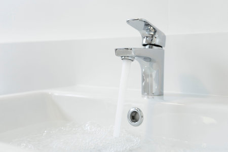Water faucet and sink in modern bathroom with copy space.