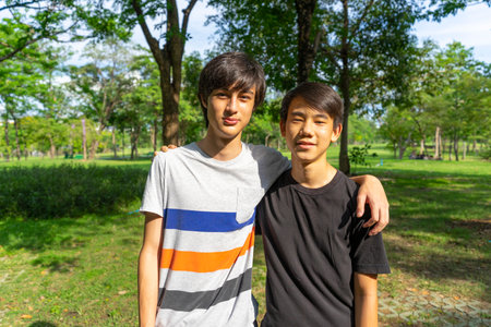 Two young Asian boys smiling and looking at camera in the park.の写真素材
