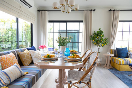 Plate setting with yellow handkerchief on wood table with artificial flowers on the dining table.