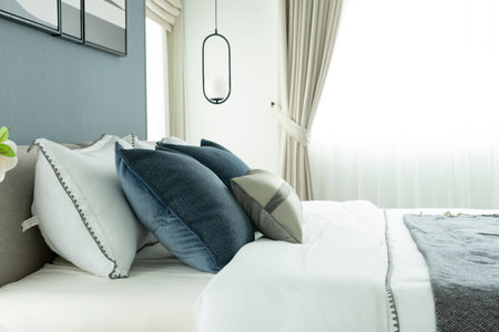 Stylish Bedroom in blue and white tone pillows setting. Cozy bedroom with art wall.の写真素材