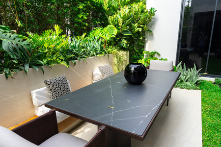 Table and chairs in the garden with black and white marble table.