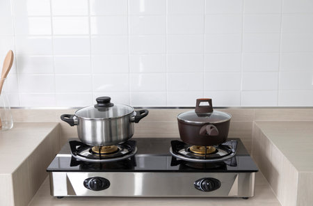 Stainless steel cooking pot on gas stove in modern kitchen.の写真素材