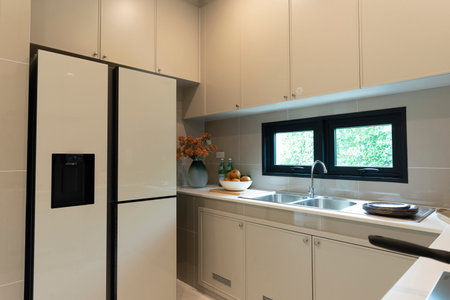 interior of modern kitchen with white cabinets and black faucet