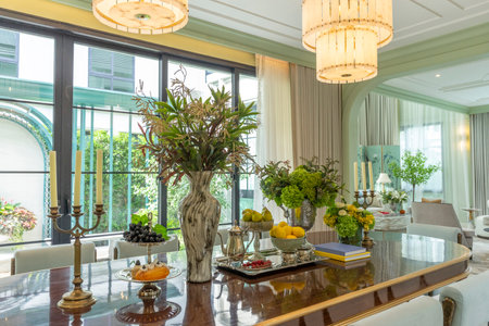 Beautiful luxurious traditional style dining room with bouquets of flowers on the table. Elegance dinning table with luxurious pendant.の写真素材