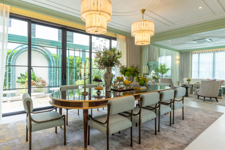 Beautiful luxurious traditional style dining room with bouquets of flowers on the table. Elegance dinning table with luxurious pendant.の写真素材
