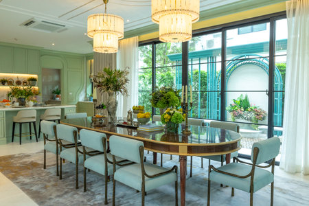 Beautiful luxurious traditional style dining room with bouquets of flowers on the table. Elegance dinning table with luxurious pendant.の写真素材