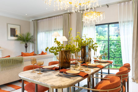 Beautiful luxurious traditional style modern dining room with bouquets of flowers on the table. Elegance dinning table with luxurious pendant.の写真素材