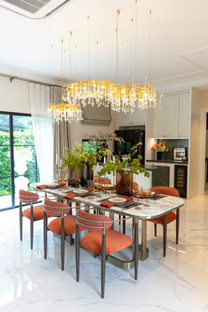 Beautiful luxurious traditional style modern dining room with bouquets of flowers on the table. Elegance dinning table with luxurious pendant.の写真素材