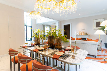 Beautiful luxurious traditional style modern dining room with bouquets of flowers on the table. Elegance dinning table with luxurious pendant.の写真素材