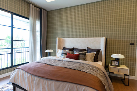 Interior of brown bedroom with a headboard and modern carpet, painting on wall and side table lamps