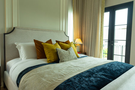 comfortable pillow on bed with light lamp decoration in hotel bedroom interiorの写真素材