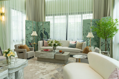 Interior of a luxurious sitting room with bay window sofas and coffee table. White and green tone of...