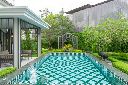 Outdoor swimming pool with green garden in luxury house. Nobody insideの写真素材
