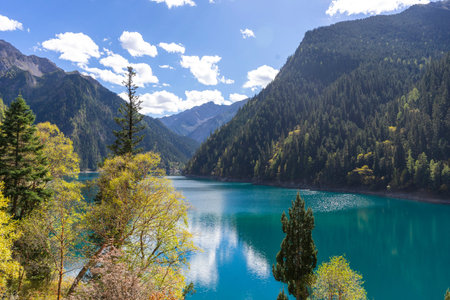 Beautiful view of the Long Lake among colorful fall woods and mountains in Jiuzhai Valley National Park in China.の写真素材