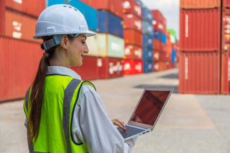 Portrait of a female worker working with a laptop in a container terminal