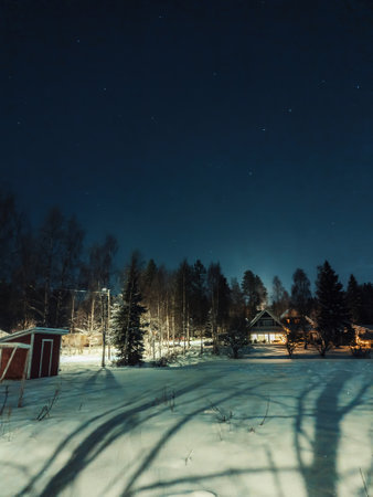 Starry night sky above house in snowy winter forest in Rovaniemi, Laplandの写真素材