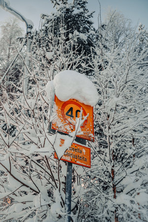 40kph sign covered in snow in forest in Rovaniemi, Lapland in winterの写真素材