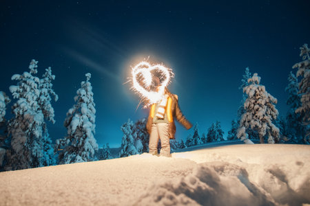 Girl with sparkler in the snow in Lappish wilderness in Rovaniemi, Laplandの写真素材
