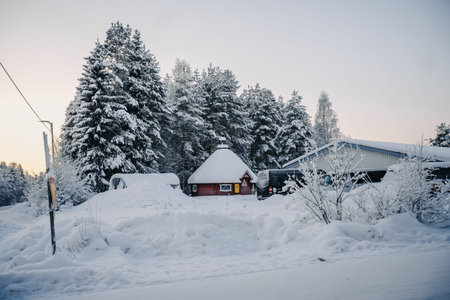 Red sauna next to hostel in front of snowy trees in Rovaniemi, Lapland