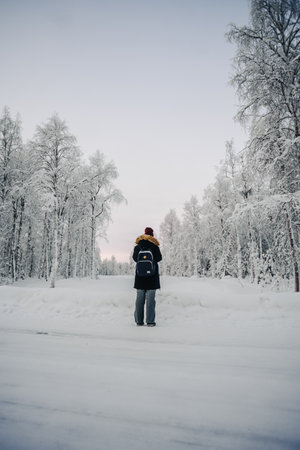 Girl taking photos of snowy forest in Rovaniemi, Laplandの写真素材