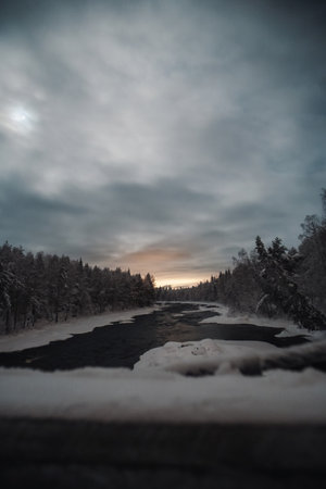 Vikakongas arctic river through snowy winter forest in Rovaniemi, Laplandの写真素材