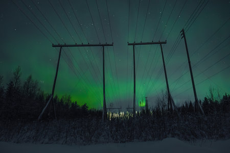 Green aurora in sky behind pylons over Rovaniemi Lapland countrysideの写真素材