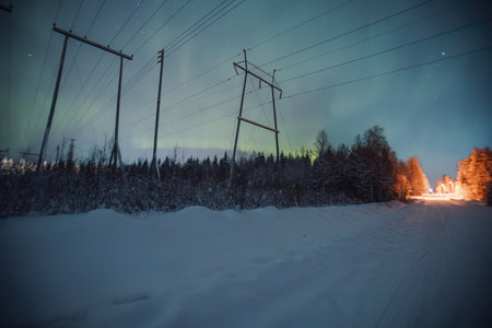 Northern lights over arctic forest behind pylons in Rovaniemi, Laplandの写真素材