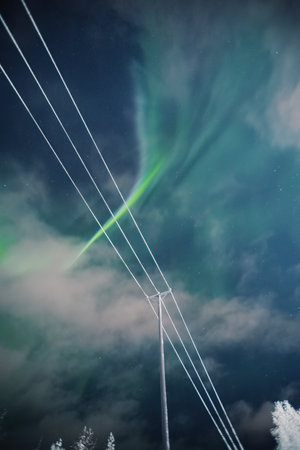 Strong northern lights behind faint clouds in Rovaniemi, Laplandの写真素材