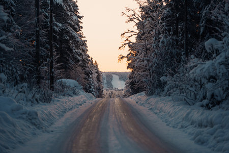 Icy road through snowy forest to Ounasvaara ski resort in Rovaniemi, Laplandの写真素材