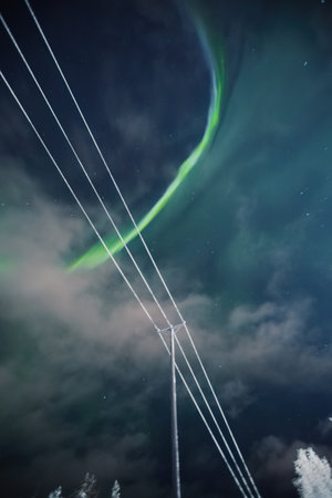 Strong aurora borealis above snowy power lines in Rovaniemi, Laplandの写真素材