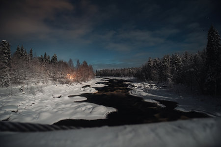 Night time shot of arctic river through snowy forest in Rovaniemi, Laplandの写真素材