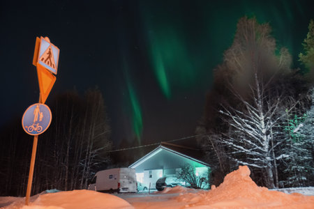 Strong green aurora in winter over house in forest in Rovaniemi, Laplandの写真素材